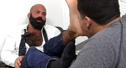 Bald bearded hunk foot worshipped and licked by young lad