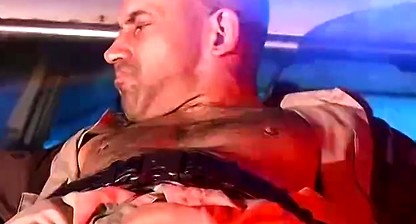 Officer Derek da Silva bound to the hood of a car