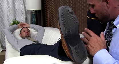 Businessman has his feet and toes sucked one by one by gay